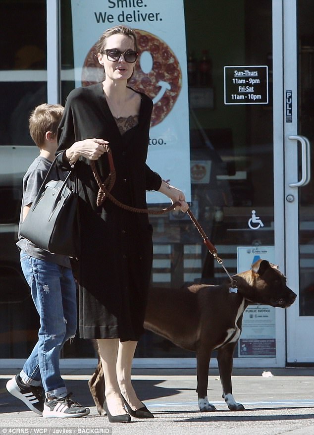 Family matters: Her son, meanwhile, stayed close by his mother during the trip