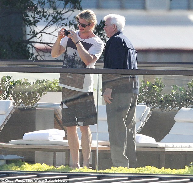 Family ties: Chris was seen taking snaps with his grandfather during an outing in Sydney