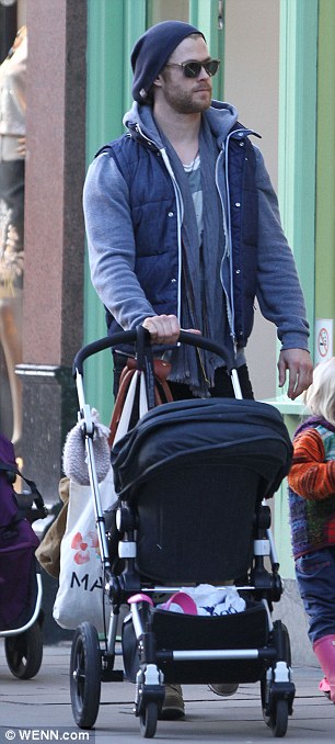 Leave the pushing to dad: The actor was in control of the stroller during the family day out while Elsa enjoyed checking out the merchandise in a few boutiques